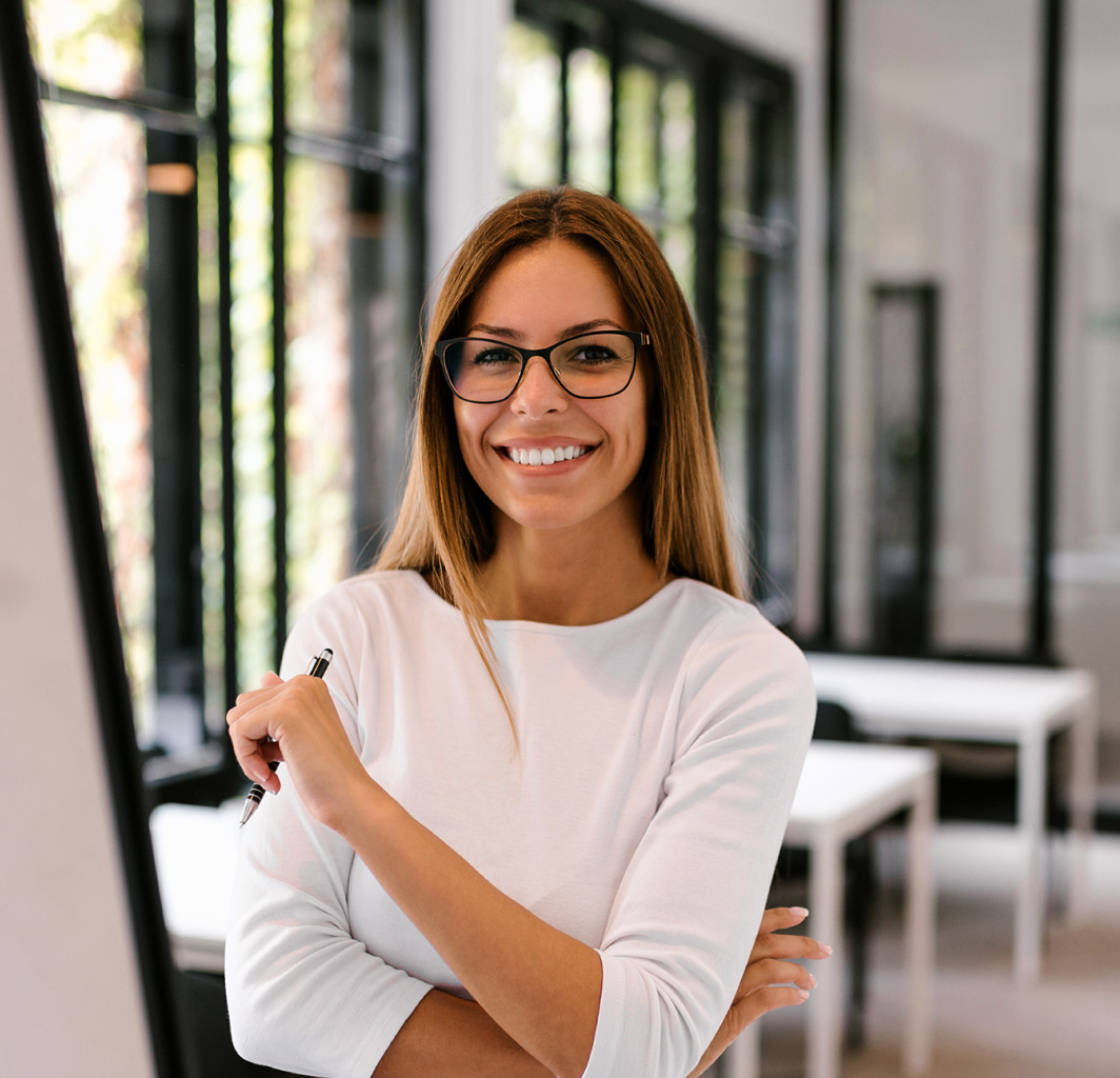 Confident business woman holding a pen in an office